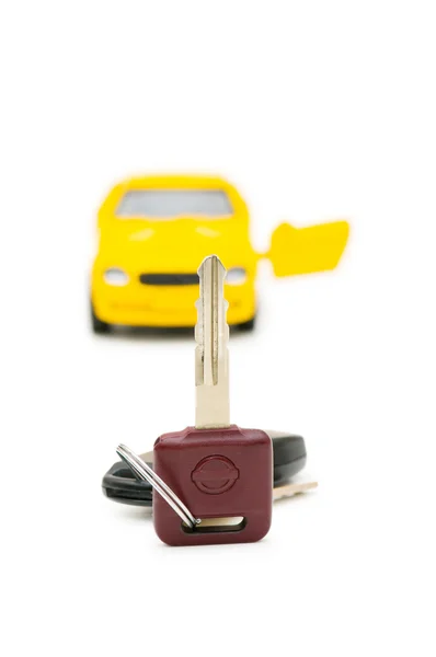 Auton avaimet ja auton taustalla — kuvapankkivalokuva