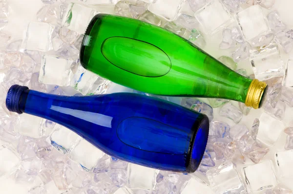 Бутылки воды на кубиках льда — стоковое фото