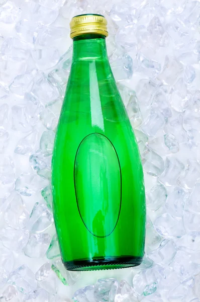Garrafa verde de água em cubos de gelo — Fotografia de Stock