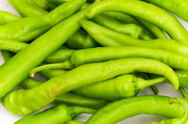 Groene paprika's in de plaat geïsoleerd — Stockfoto