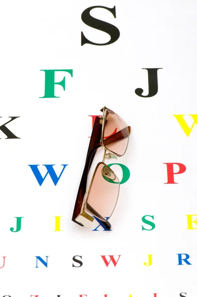 Optical glasses over the eye test table — Stock Photo, Image