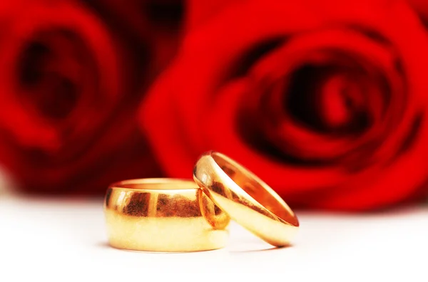 Twee trouwringen en rode rozen — Stockfoto