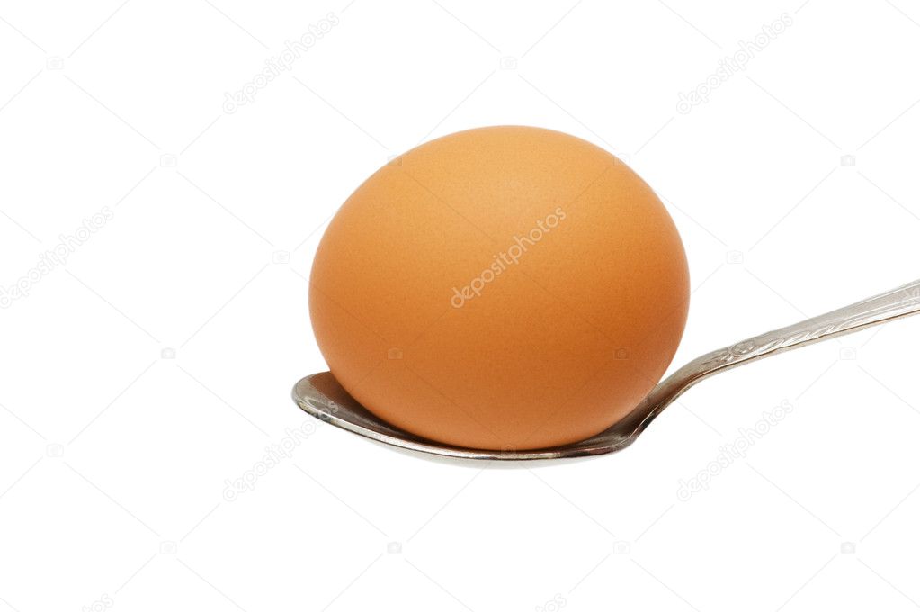 Brown egg in the spoon isolated