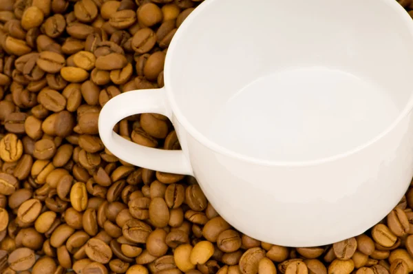 Белая чашка на фоне кофе — стоковое фото
