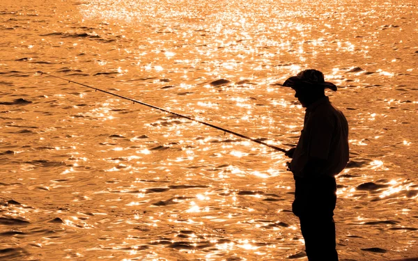 Pescador solitário durante o pôr do sol — Fotografia de Stock