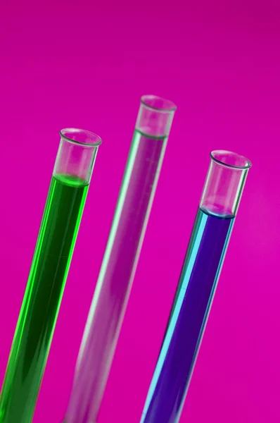 Drie retorten in het lab tegen roze — Stockfoto