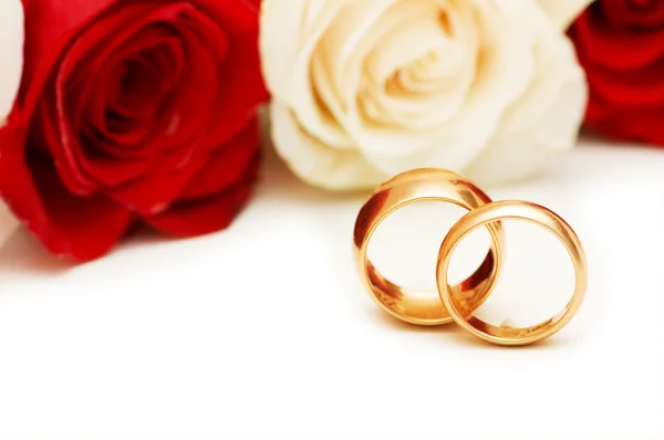 Gyllene ringar och rosor isolerade — Stockfoto