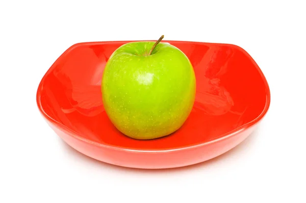 Зеленое яблоко в красной тарелке — стоковое фото