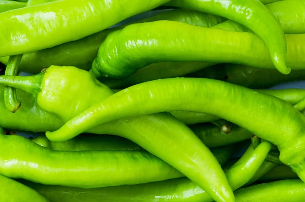 Zelené papriky v deska izolovaná — Stock fotografie