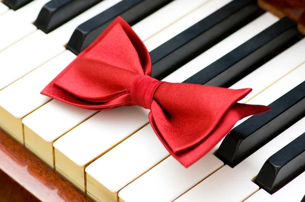 Червона краватка на клавішах піаніно — стокове фото
