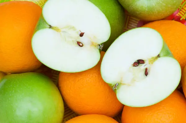 Närbild av halvskurna apelsiner och äpplen — Stockfoto