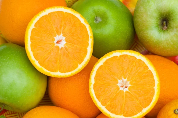 Yarısı kesilmiş portakal ve elmaları kapat — Stok fotoğraf