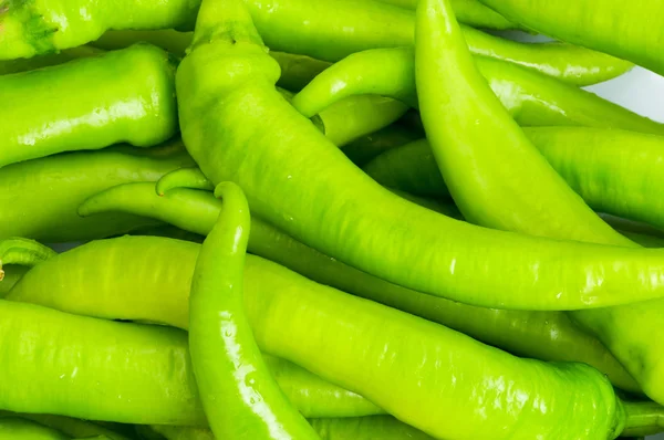 Zelené papriky v deska izolovaná — Stock fotografie