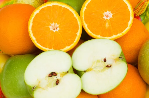 Närbild av halvskurna apelsiner och äpplen — Stockfoto