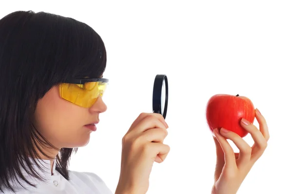 Female scientist looking at apple — Stock Photo, Image