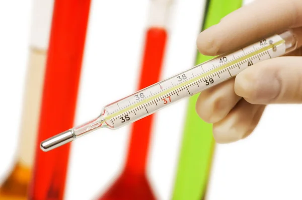 Hand holding thermometer and tubes — Stock Photo, Image