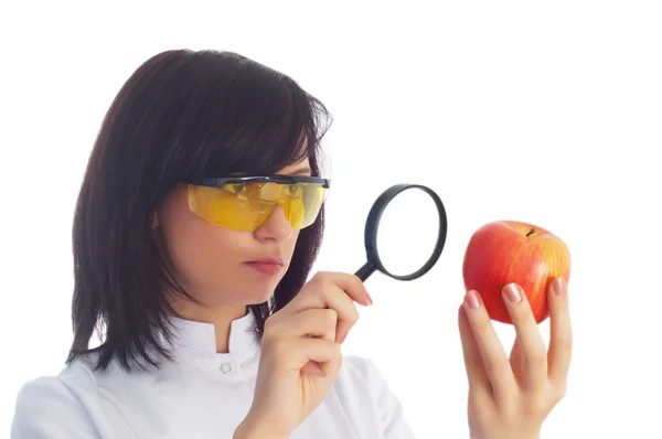 Женщина-ученый смотрит на яблоко — стоковое фото