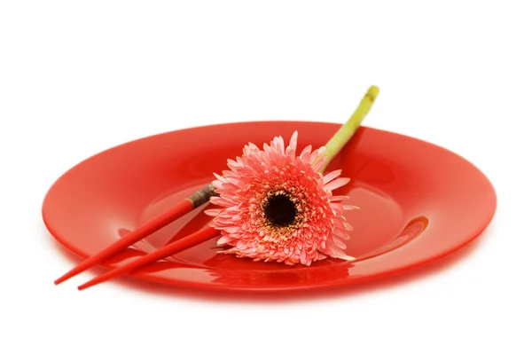 Rote Blume und Teller mit Essstäbchen — Stockfoto