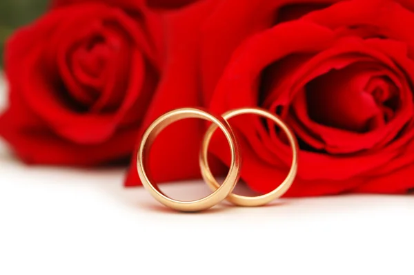 Dois anéis de casamento e rosas vermelhas Imagens Royalty-Free
