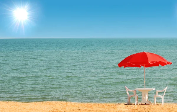 Stół, krzesła i parasol na plaży — Zdjęcie stockowe