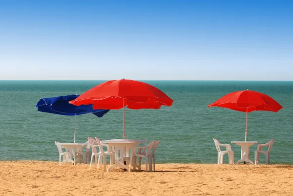 Tavolo, sedie e ombrellone in spiaggia — Foto Stock
