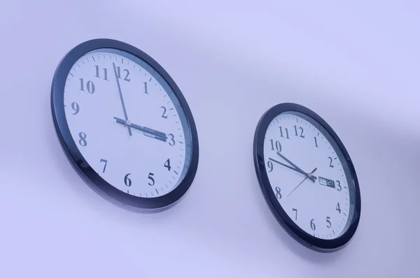 Toned image of two clocks on the wall — Stock Photo, Image