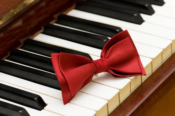 ผูกโบว์แดงบนปุ่มเปียโน — ภาพถ่ายสต็อก