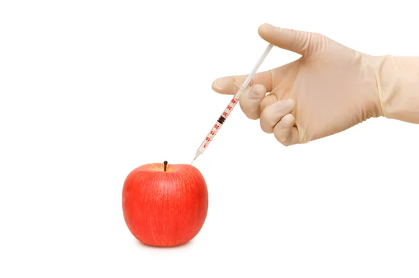 Hand med sprutan och rött äpple — Stockfoto