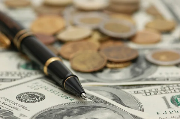 Penna och pengar - fokusera på pennans spets — Stockfoto