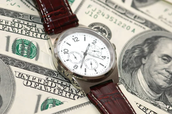 Relógio de mão sobre os cem dólares — Fotografia de Stock