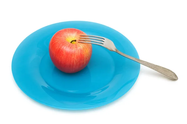 Красное яблоко с изолированной вилкой — стоковое фото