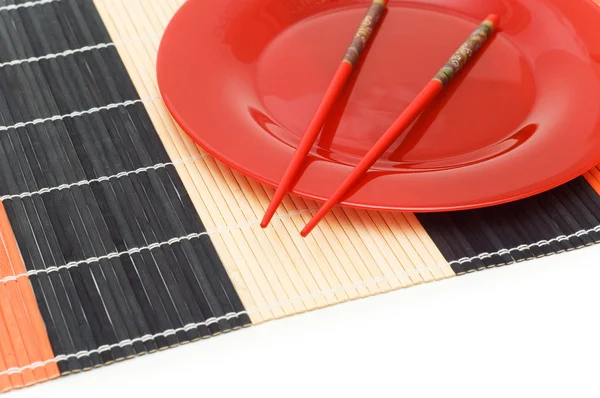 Красная тарелка с палочками для еды — стоковое фото