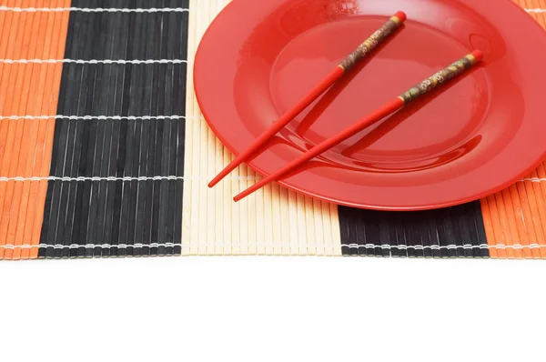 Красная тарелка с палочками для еды — стоковое фото