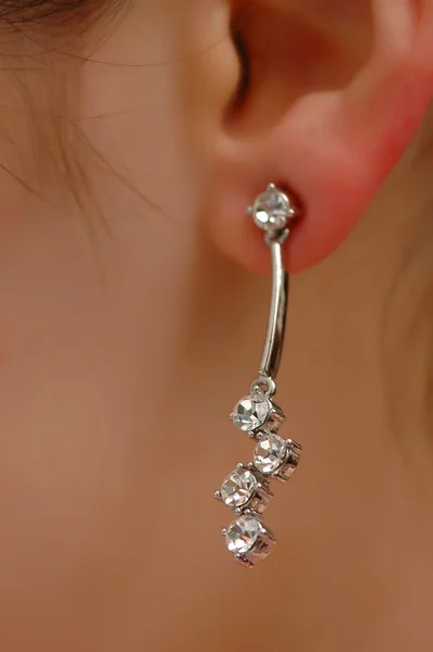 Earring with diamonds on the woman ear — Stock Photo, Image