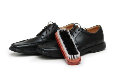 Black leather shoes and brush isolated clipart