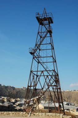 Old oil derrick during bright summer day clipart