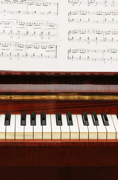 Пианино с черно-белыми клавишами и нотами — стоковое фото