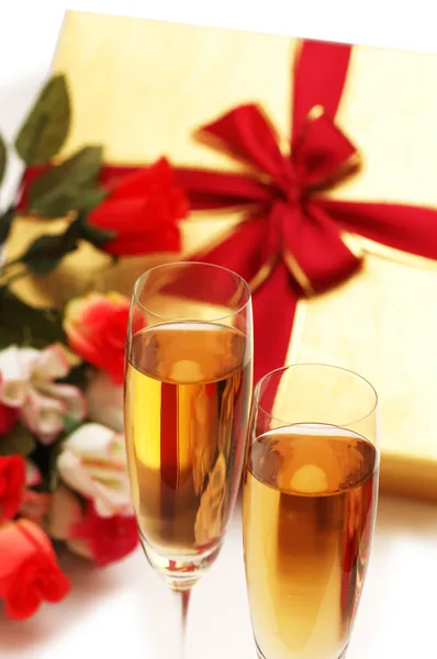 Два бокала вина, подарочная коробка и цветы — стоковое фото