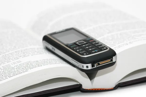 Мобільний мобільний телефон над книгою — стокове фото