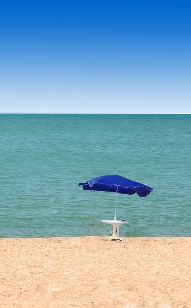 Tabela i parasol na plaży — Zdjęcie stockowe