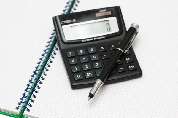 Calcolatrice e penna sul libro — Foto Stock