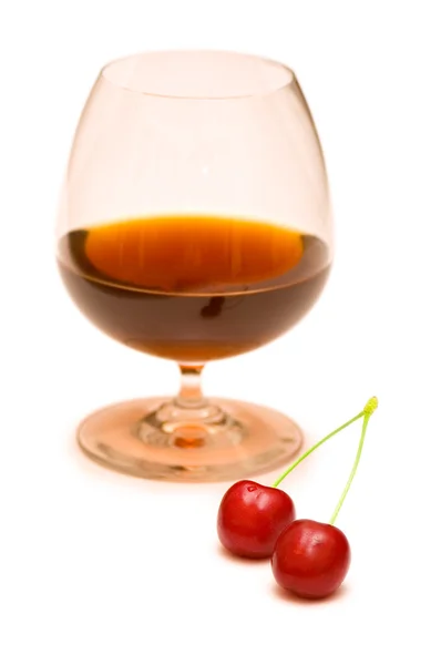 Бокал вина и две вишни — стоковое фото