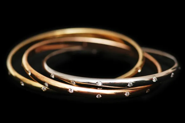 Três pulseiras de ouro isolado — Fotografia de Stock