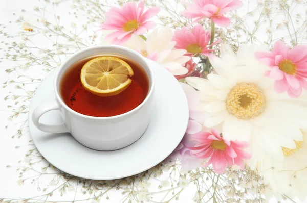 Чашка чая с лимоном на цветке — стоковое фото