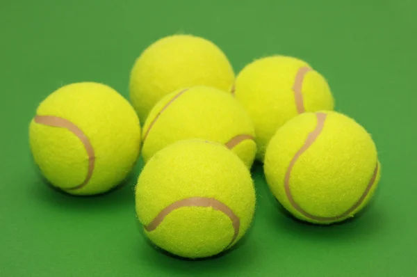 Шесть теннисных мячей на зеленом — стоковое фото