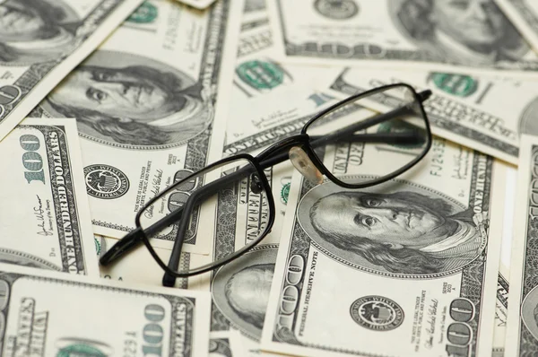 Reading glasses over dollars — Stock Photo, Image