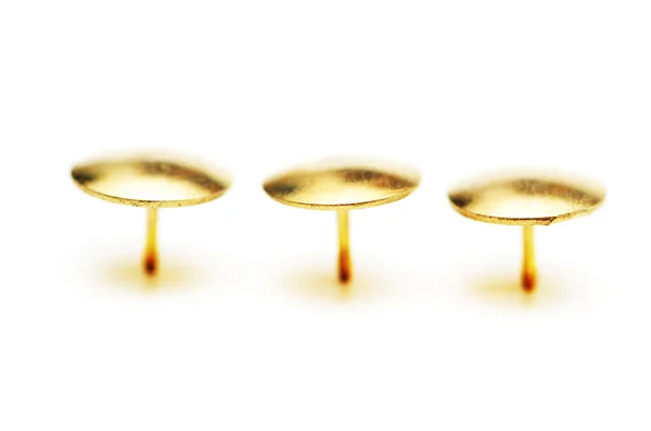 Altın pimleri üzerinde beyaz izole — Stok fotoğraf