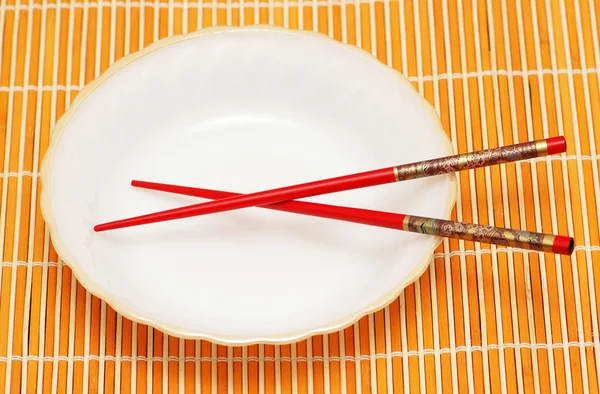 Beyaz tabak ve yemek çubukları — Stok fotoğraf