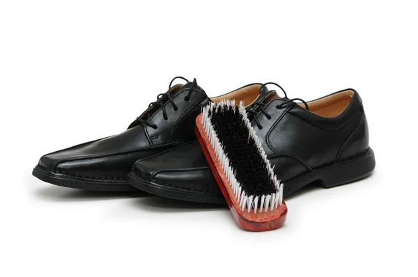 stock image Black leather shoes and brush isolated