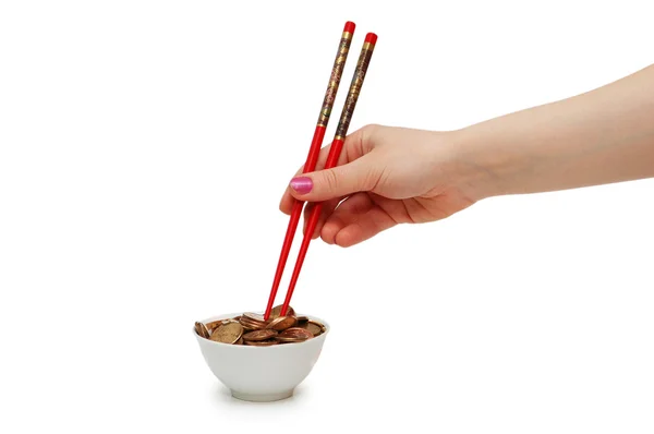 Hand met rode stokjes eten munten — Stockfoto